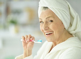 An older woman brushing his teeth