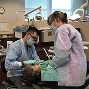 Dentist and team member treating patient
