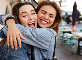 Closeup of two friends hugging and smiling