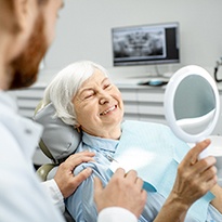older woman smiling after getting dental implants in Covina