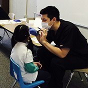 Dr. Tran offering dental care for young girl