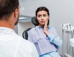 Young woman with toothache talking to San Dimas dentist
