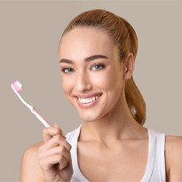 woman brushing teeth for dental implant care in Covina 