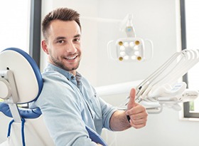 man sitting in the dental chair and giving a thumbs-up 
